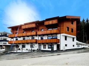 ein Gebäude mit Holzbalkonen darüber in der Unterkunft Apartment Griass di Fügen in Fügen