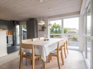 een keuken en eetkamer met een tafel en stoelen bij Holiday home Fanø CLVIII in Fanø