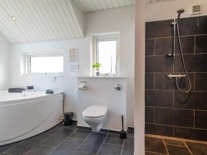 y baño con aseo, bañera y ducha. en Cozy Coastal Retreat in Fano-By Traum, en Fanø 33 fotos más