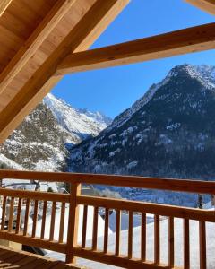 a view from the deck of a cabin with snow covered mountains at Maison Cluaran in Vénosc