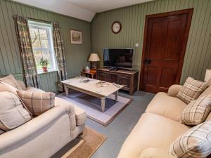 a living room with two couches and a tv at Rottal Bothy in Millton of Clova