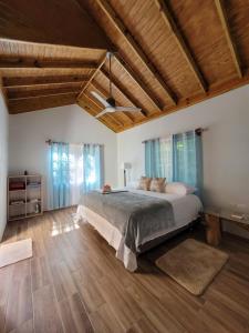 ein Schlafzimmer mit einem großen Bett und Holzdecken in der Unterkunft Ecoscape Jamaica - Cottages by the river in Ocho Rios