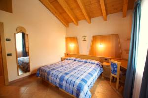 a bedroom with a bed and a desk and a mirror at Miky House - Appartamenti Abar in Livigno