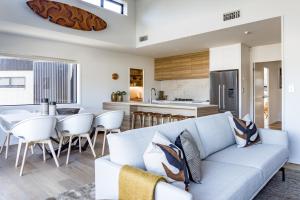 a living room and kitchen with a couch and a table at Harbourview Haven in Raglan