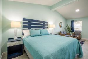 1 dormitorio con 1 cama grande y colcha azul en Salt Air Inn & Suites, en Atlantic Beach