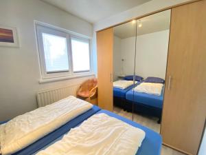 a bedroom with two beds and a mirror at Appartement Walvis nr. 16 in Vrouwenpolder
