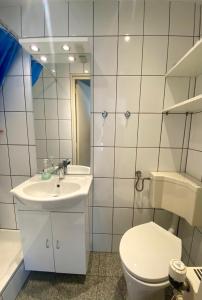 een witte badkamer met een toilet en een wastafel bij Appartement Walvis nr. 16 in Vrouwenpolder