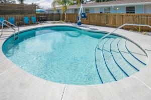 a large swimming pool in a yard with blue chairs at Salt Air Inn & Suites in Atlantic Beach