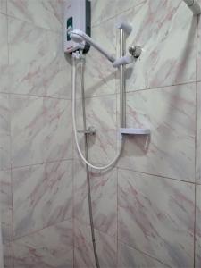 a shower in a bathroom with a white marble wall at Felipa Beach Residence - Ilang Ilang in Dumaguete