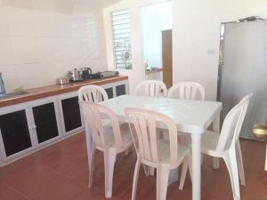 a kitchen with a white table and white chairs at Felipa Beach Residence - Ilang Ilang in Dumaguete