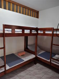 a room with three bunk beds in a house at Felipa Beach Residence - Ilang Ilang in Dumaguete