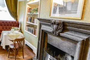 a fireplace with a lion on it in a room with a table at Albergo Alla Posta in Trieste