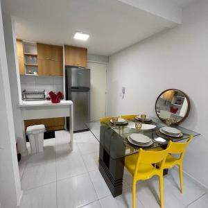 eine Küche und ein Esszimmer mit einem Tisch und gelben Stühlen in der Unterkunft Flat Garden 113 Muro Alto Condominio Clube in Porto De Galinhas