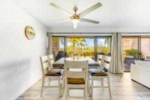 a dining room with a table and chairs and a ceiling fan at Newly Renovated Condo Stand Up Paddle Boards Included! in Kailua-Kona