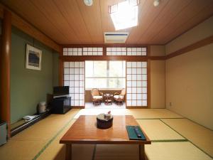 una habitación con una mesa en el medio de una habitación en Hotel Nosegawa en Nosegawa