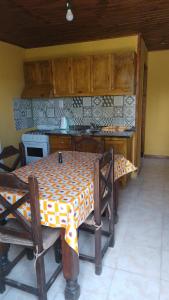 y cocina con mesa, sillas y fogones. en Hospedaje El TaTa en Colonia Las Rosas