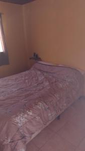 a bed in the corner of a room at Hospedaje El TaTa in Colonia Las Rosas