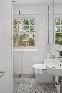 Un baño blanco con bañera y lavabo. en Mulwarree Avenue Apartments by Urban Rest, en Sídney