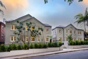 a large white house with palm trees in front of it at Mulwarree Avenue Apartments by Urban Rest in Sydney