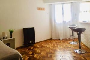 a room with a bed and a television and a wooden floor at Mar de Anto in Puerto Madryn