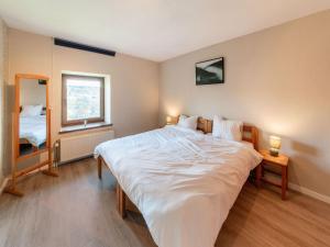 um quarto com uma grande cama branca e uma janela em Holiday home in Waimes with natural surroundings em Waimes