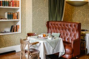 a restaurant with a table and a leather chair at Albergo Alla Posta in Trieste
