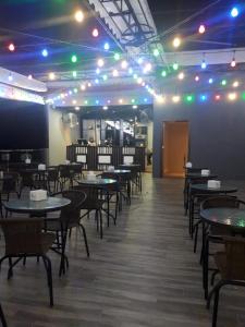 una sala da pranzo con tavoli, sedie e luci di Hotel Morena Batam a Batam Center