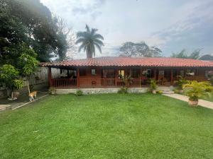 a house with a large yard in front of it at Hotel Cabañas De Rozo in Rozo