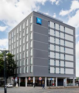 ein großes Gebäude mit blauem Schild drauf in der Unterkunft Ibis budget Osnabrück City in Osnabrück