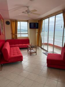 a living room with red couches and a view of the ocean at Apartamento en Atacames con vista al mar in Atacames