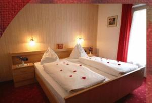 マルテッロにあるHotel Ortlerhofのベッドルーム1室(赤いバラの大きなベッド1台付)