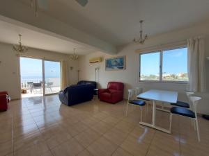 a living room with a table and chairs and the ocean at SEA CAVES suite in Peyia