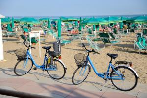 due biciclette parcheggiate sulla spiaggia con sedie di Hotel Jadran a Lido di Jesolo