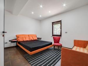 a bedroom with a bed and a red chair at Belvilla by OYO Modern villa in Nissoria with pool in Nissoria