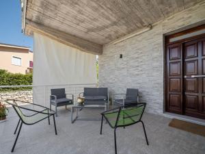 a patio with chairs and a table and a door at Belvilla by OYO Modern villa in Nissoria with pool in Nissoria