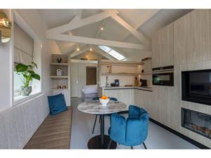 cocina con mesa y 2 sillas azules en Luxury holiday home 250 meters from the beach en Domburg