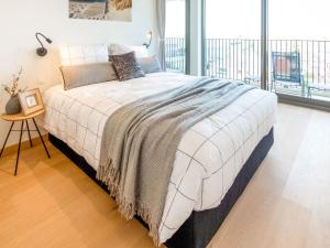 uma cama grande num quarto com uma janela grande em Luxurious Crystal Sea View apartment with 2 terraces em Oostende