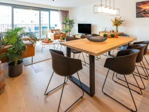 uma sala de estar com uma mesa de madeira e cadeiras em Luxurious Crystal Sea View apartment with 2 terraces em Oostende