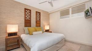 a bedroom with a white bed and two lamps at Penthouse - Palm Cove in Palm Cove