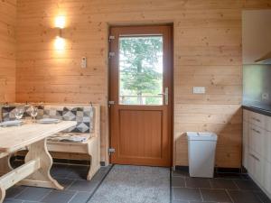 cocina con puerta de madera y mesa de madera en Quaint Chalet in Rogery with Garden Terrace and Barbecue, en Rogery