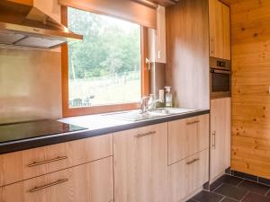 cocina con fregadero y ventana en Quaint Chalet in Rogery with Garden Terrace and Barbecue, en Rogery