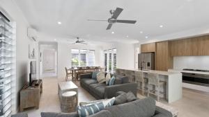 Coastal Vibes - Palm Cove في بالم كوف: غرفة معيشة مع أريكة وغرفة طعام