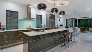 a kitchen with a large island with bar stools at Castaways - Palm Cove in Palm Cove