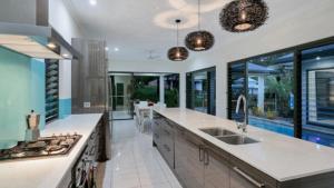 a large kitchen with a sink and a stove at Castaways - Palm Cove in Palm Cove