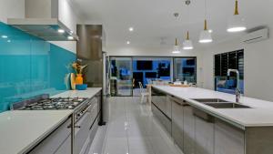 a kitchen with white countertops and blue walls at Sandcastles - Palm Cove in Palm Cove