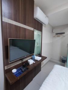a room with a tv and a bed and a mirror at Hotel Morena Batam in Batam Center