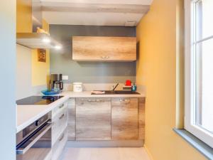a kitchen with wooden cabinets and a sink at Stunning Apartment in heart of Dambach La Ville in Dambach-la-Ville