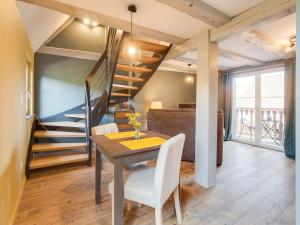 ein Esszimmer mit einem Tisch und einer Treppe in der Unterkunft Stunning Apartment in heart of Dambach La Ville in Dambach-la-Ville