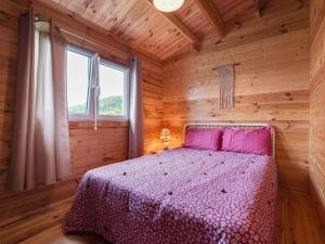 sypialnia z łóżkiem w drewnianym domku w obiekcie Secluded Chalet in Egliseneuve des Liards w mieście Égliseneuve-des-Liards