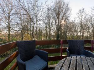 twee stoelen en een tafel op een houten terras bij Completely renovated apartment within walking distance of Veere in Veere
